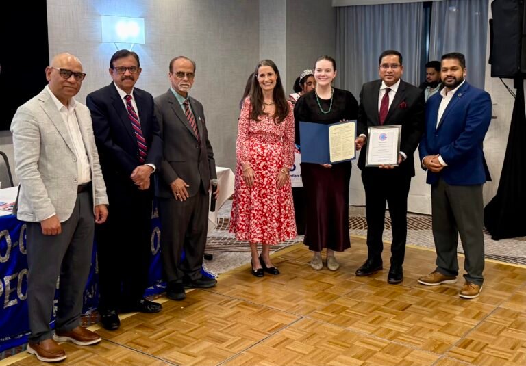From left, Ram Gupta, Johnson Myalil, Jay Bhandari, Jennifer Boysko, Maddy White, T. Vishnudatta Jayaraman (receiving the award), and Saddam Salim on August 23, 2026, at the 17th anniversary celebrations of GOPIO-Virginia, in Herndon, VA. PHOTO: GOPIO-Virginia