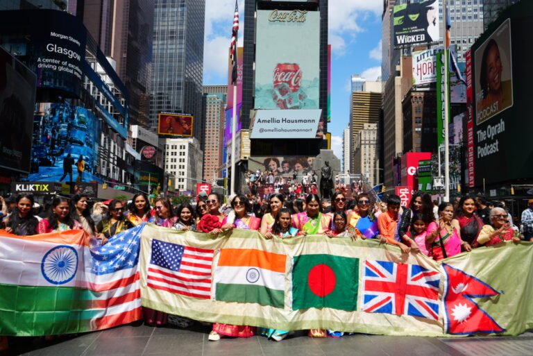Participants from diverse backgrounds come together beneath an array of international flags at the third annual Saree Goes Global USA celebration in Times Square, celebrating heritage, unity, and cultural connection. PHOTO: Anushka Roy, @shotsbynush