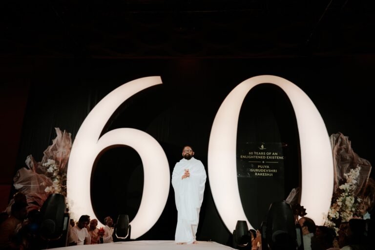 Pujya Gurudevshri Rakeshji at the 60th year banner. PHOTO: Shrimad Rajchandra Mission